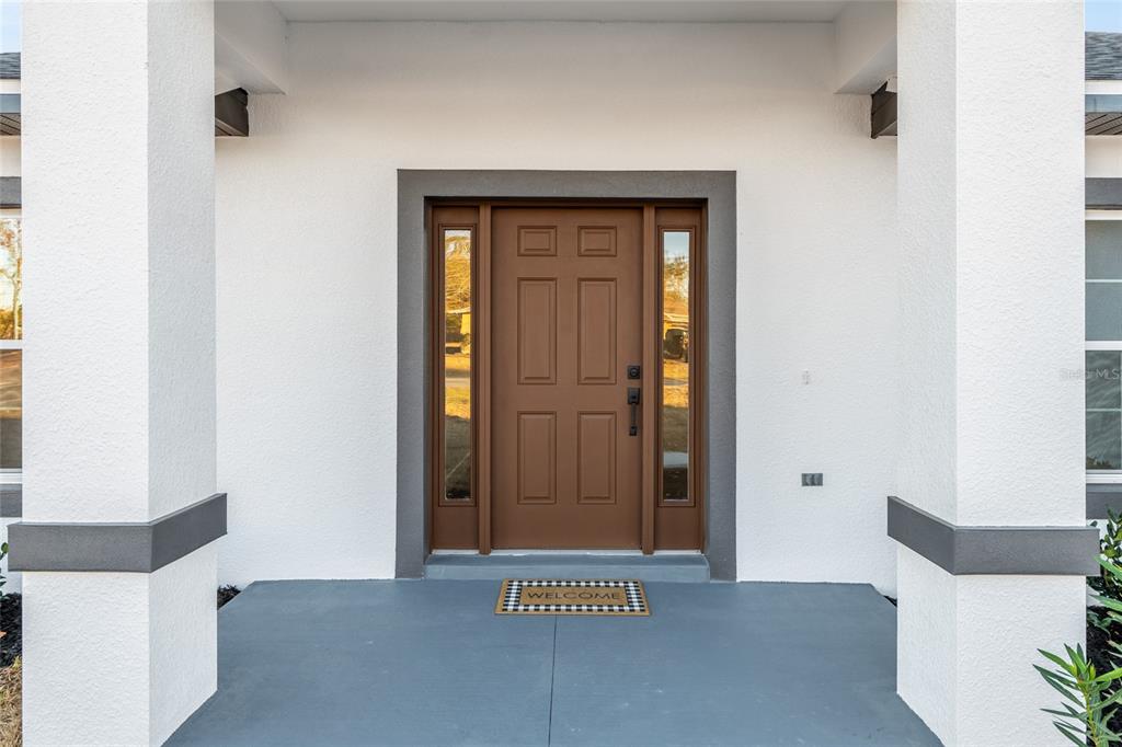 A front entryway features a brown door with sidelights and a welcome mat — 4612 SW 149TH STREET, OCALA, FL