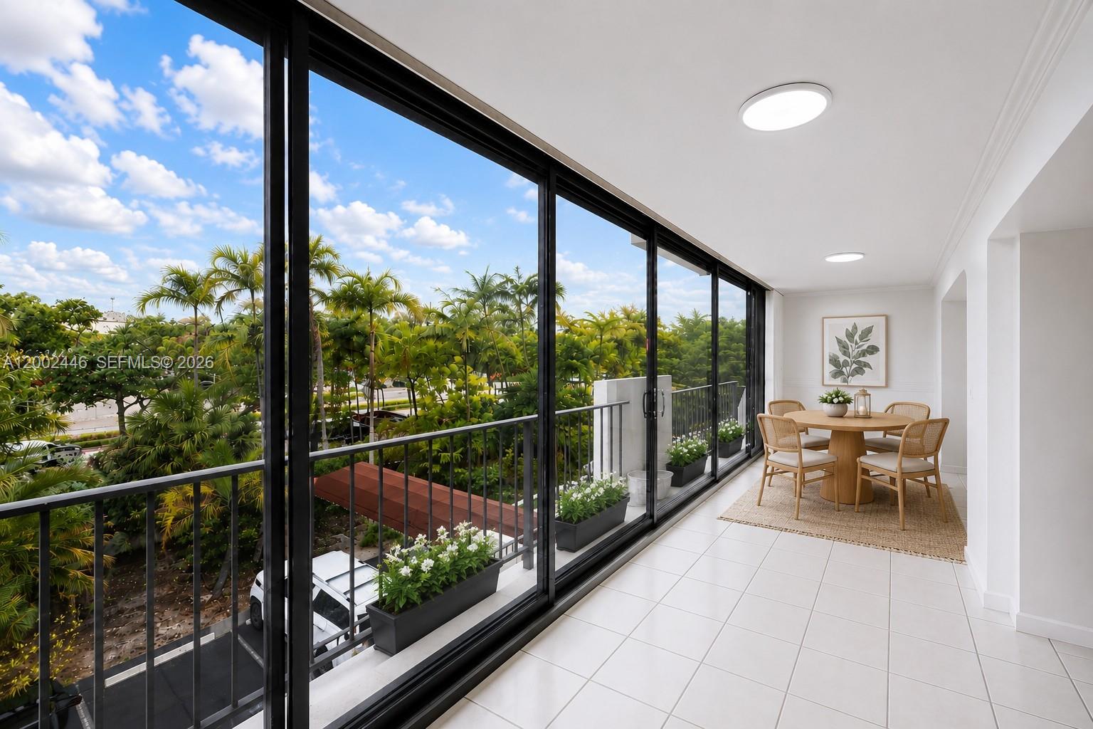 A sunroom with white tile floors, sliding glass doors, and a dining set overlooking palm trees — 77 Crandon Blvd # 3C, Key Biscayne FL 33149, KEY BISCAYNE, FL