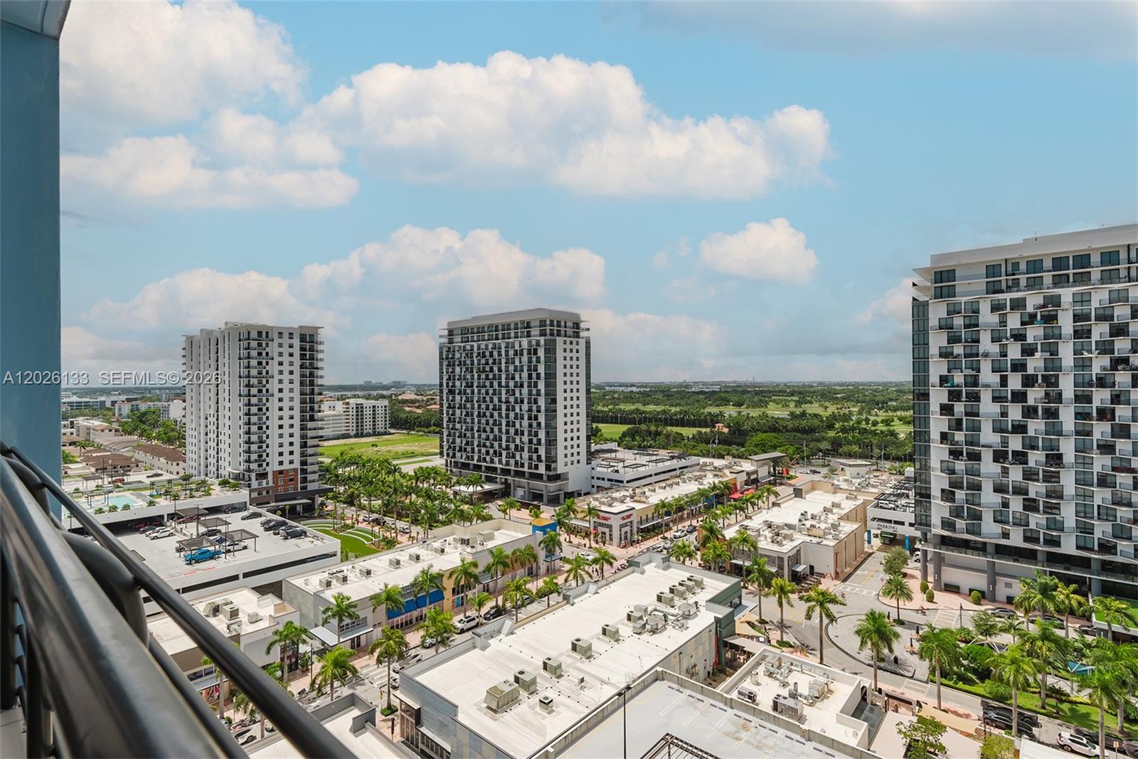 An elevated view shows multiple high-rise apartment buildings overlooking a commercial area with palm trees — 5350 NW 84th Ave # 1506, Doral FL 33166, DORAL, FL