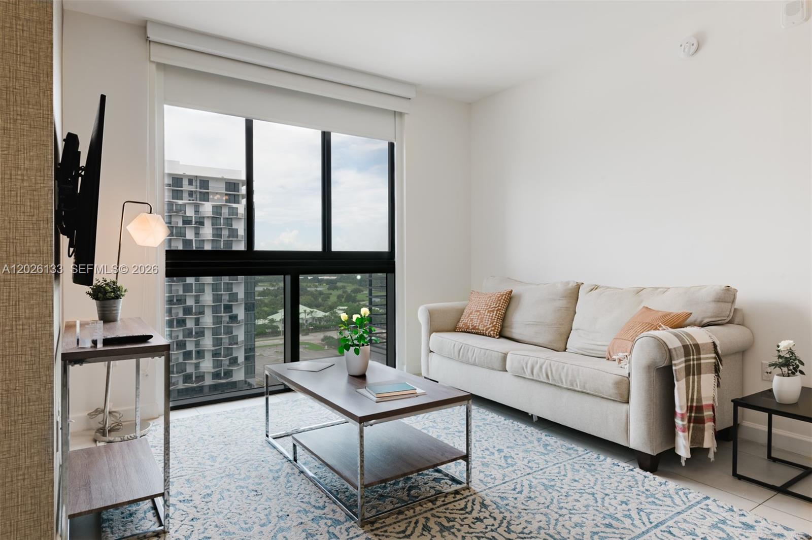 A living room features a beige sofa, a coffee table, and a large window view — 5350 NW 84th Ave # 1506, Doral FL 33166, DORAL, FL