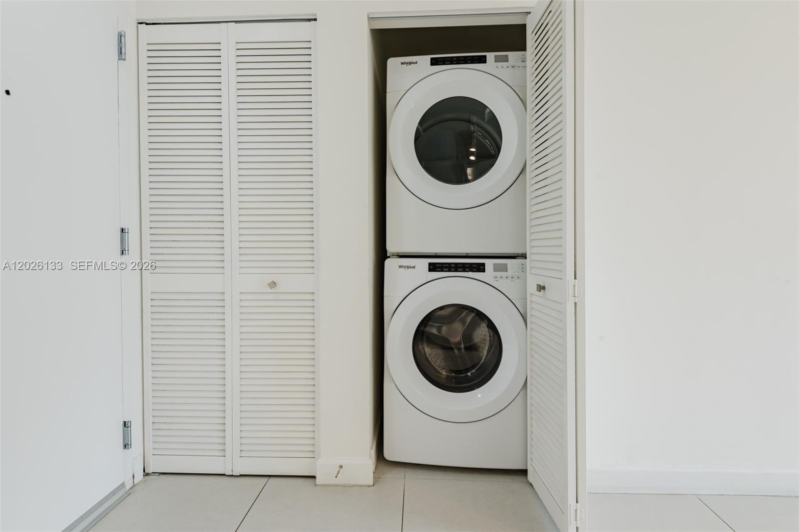 A stacked Whirlpool washer and dryer unit sits inside a white louvered closet — 5350 NW 84th Ave # 1506, Doral FL 33166, DORAL, FL