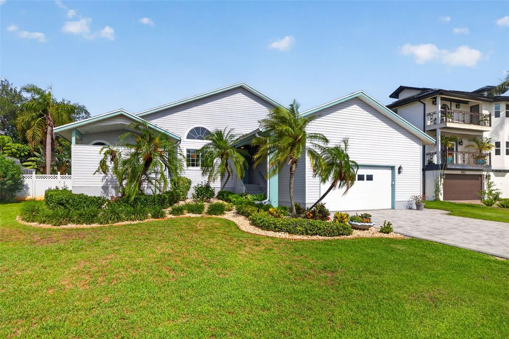 A light-colored, single-story house with a garage, palm trees, and a landscaped front yard — 615 MONTE CRISTO BOULEVARD, ST PETERSBURG, FL