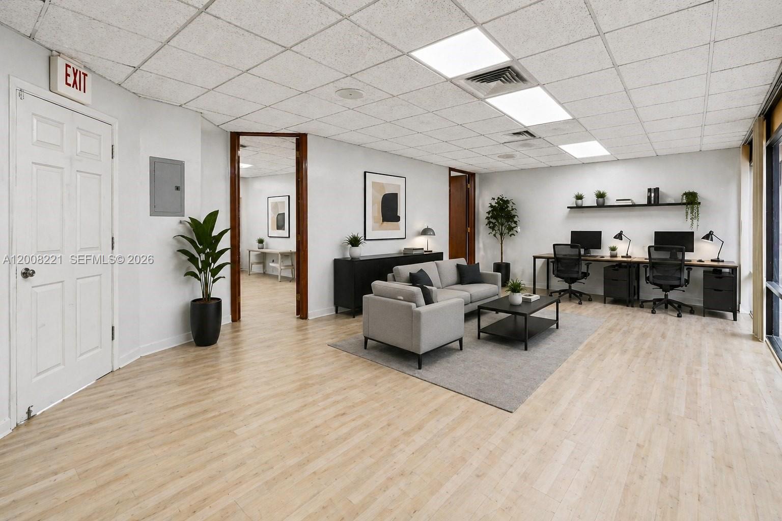 This office space features a seating area, two workstations, light wood flooring, and drop ceilings — 8358 W Oakland Park Blvd # A, Sunrise FL 33351, SUNRISE, FL