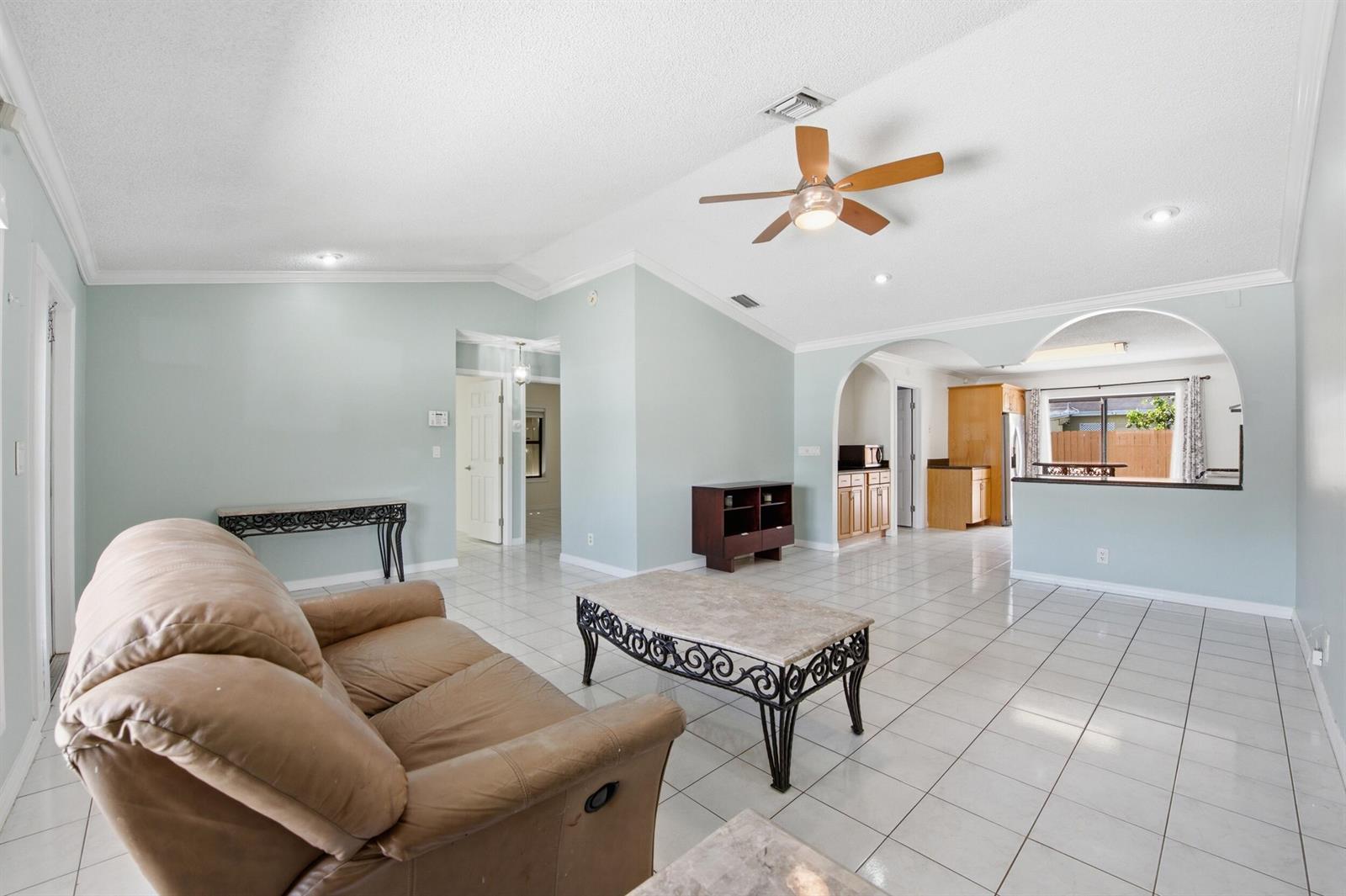 A living room with light blue walls, white tile floors, and a vaulted ceiling — 5814 Ithaca Circle E, Lake Worth FL 33463, LAKE WORTH, FL