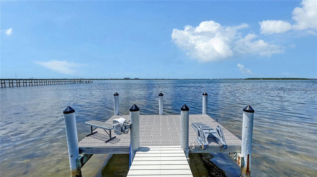 A floating dock with white pilings extends into a calm body of water — 180 HORSESHOE LOOP ROAD, TERRA CEIA, FL