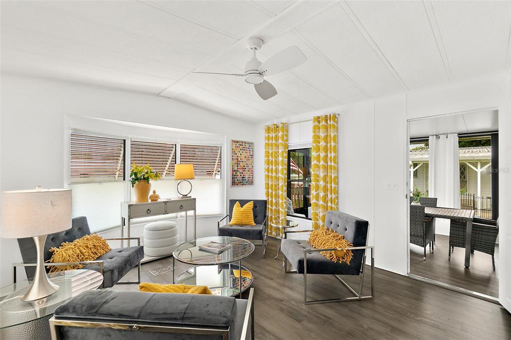 A living room features gray velvet chairs, a glass coffee table, and yellow patterned curtains — 727 ROLLING HILLS DRIVE, PORT ORANGE, FL