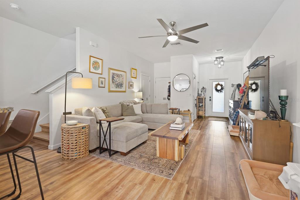 A living room features a sectional sofa, wood coffee table, and wood-look flooring — 2709 ISABELLA VALLEY COURT, BRANDON, FL
