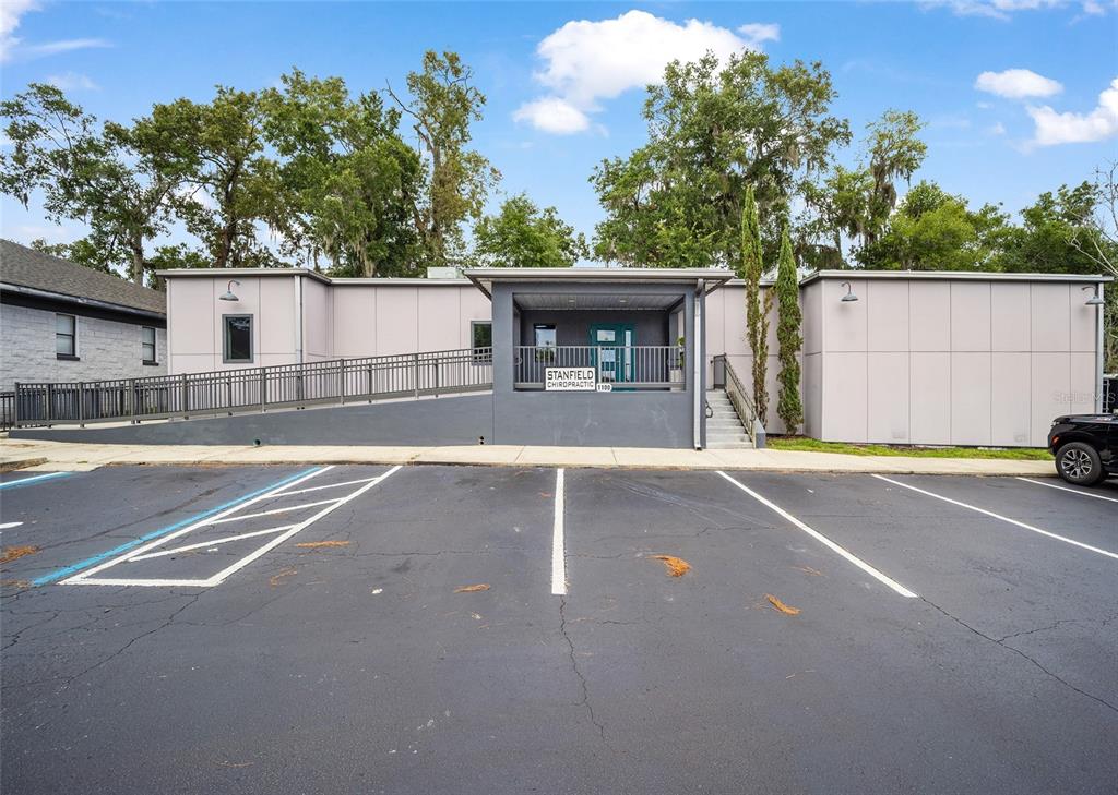 The exterior of a single-story commercial building features a ramp, stairs, and a parking lot — 2300 SE 17TH STREET UNIT 1100, OCALA, FL