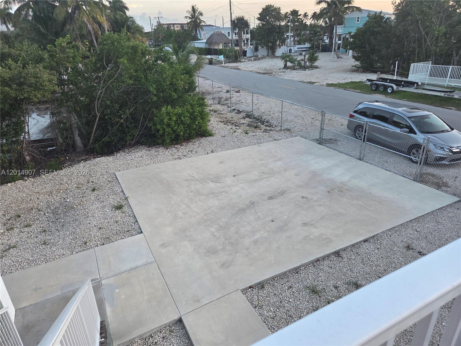 An elevated view shows a concrete parking pad, gravel yard, chain-link fence, and a minivan — 799 Hazel St # 799, Key Largo FL 33037, KEY LARGO, FL