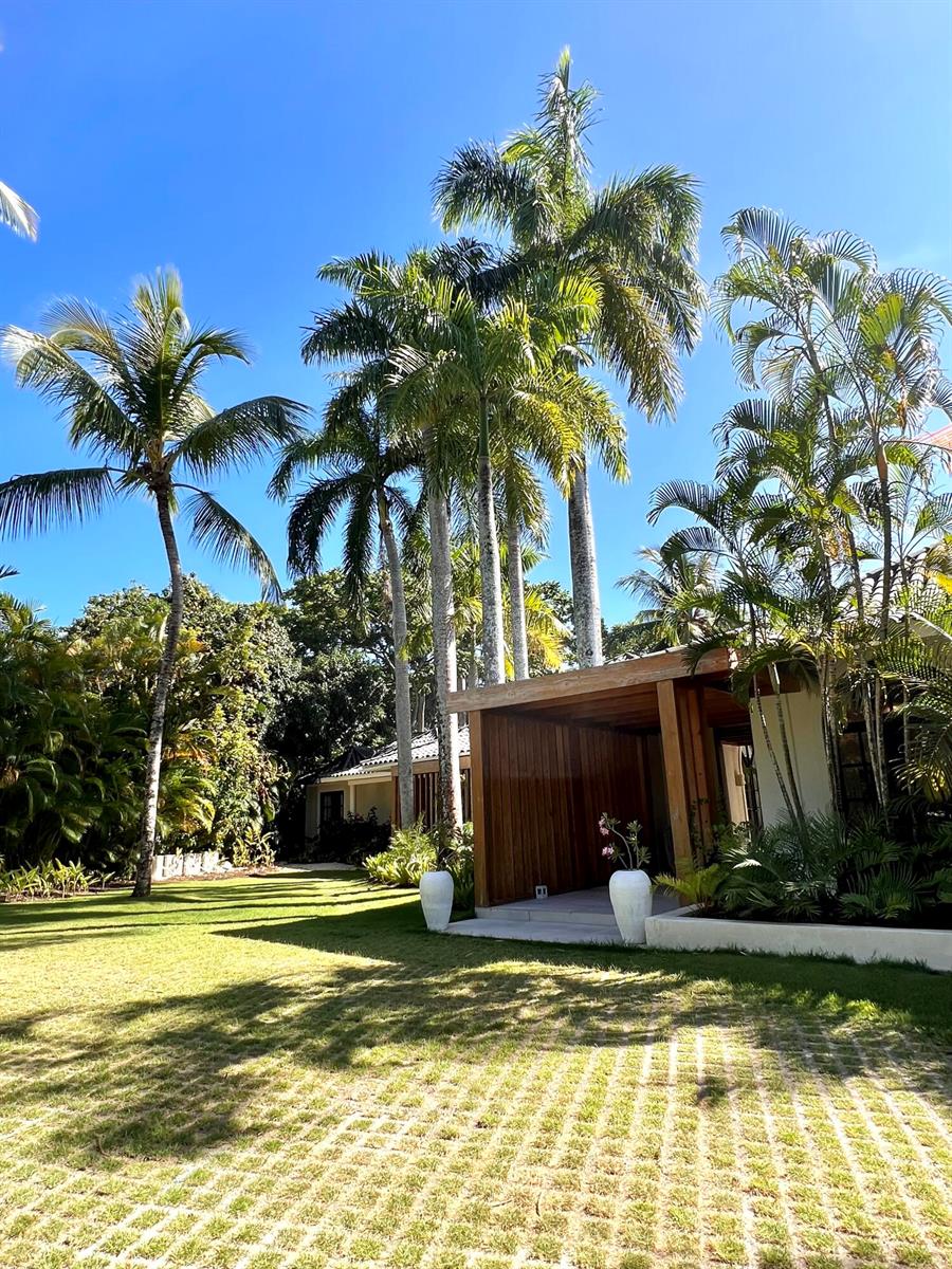 A grassy yard features a wooden pergola structure and several tall palm trees — 123456 Sea Horse Ranch Community, FL