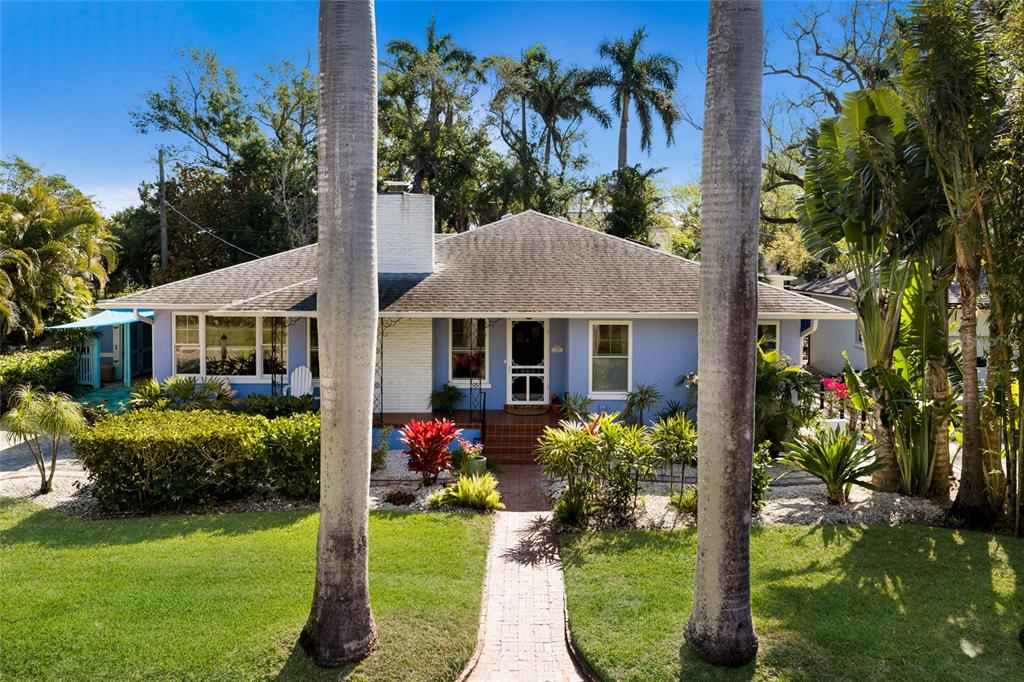 A blue single-story house with a brick walkway and palm trees in the front yard — 104 24TH STREET NW, BRADENTON, FL