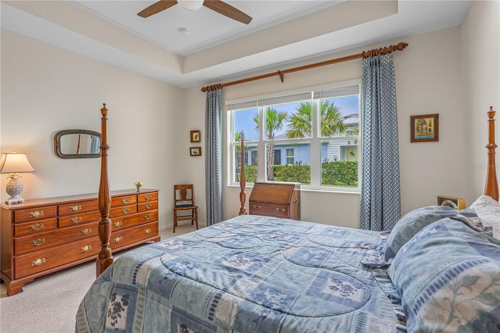 A bedroom features a four-poster bed, a wooden dresser, and a window with blue curtains — 466 MARGARITAVILLE AVENUE, DAYTONA BEACH, FL