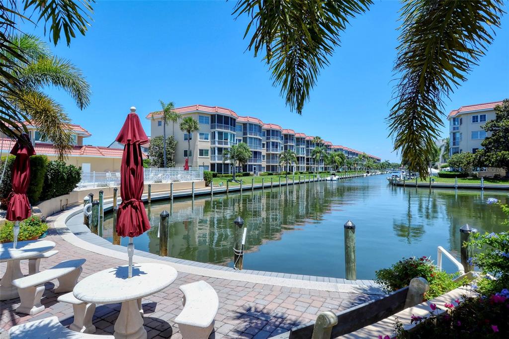 A waterfront view of a canal lined with multi-story apartment buildings and palm trees — 1257 S PORTOFINO DRIVE UNIT 307, SARASOTA, FL