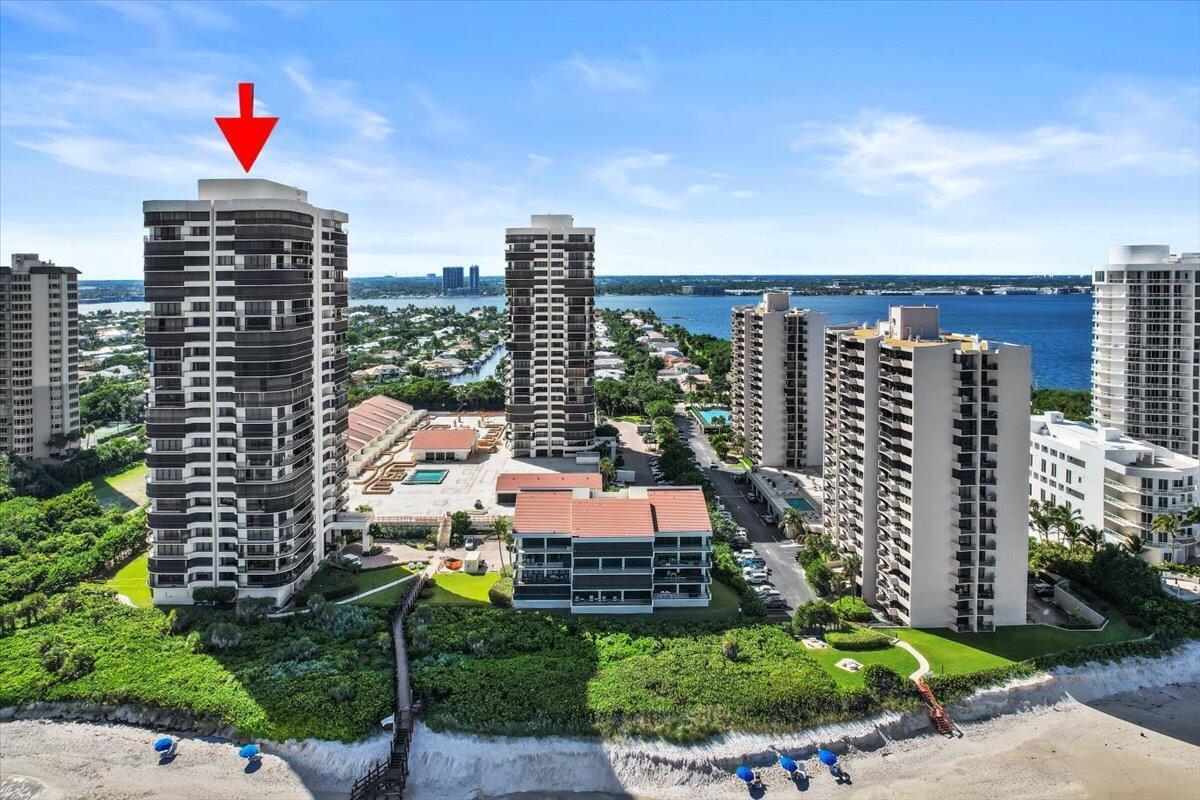 An aerial view shows several tall residential buildings situated along a sandy beach and coastline — 4000 N Ocean Drive # 2004, Singer Island FL 33404, SINGER ISLAND, FL
