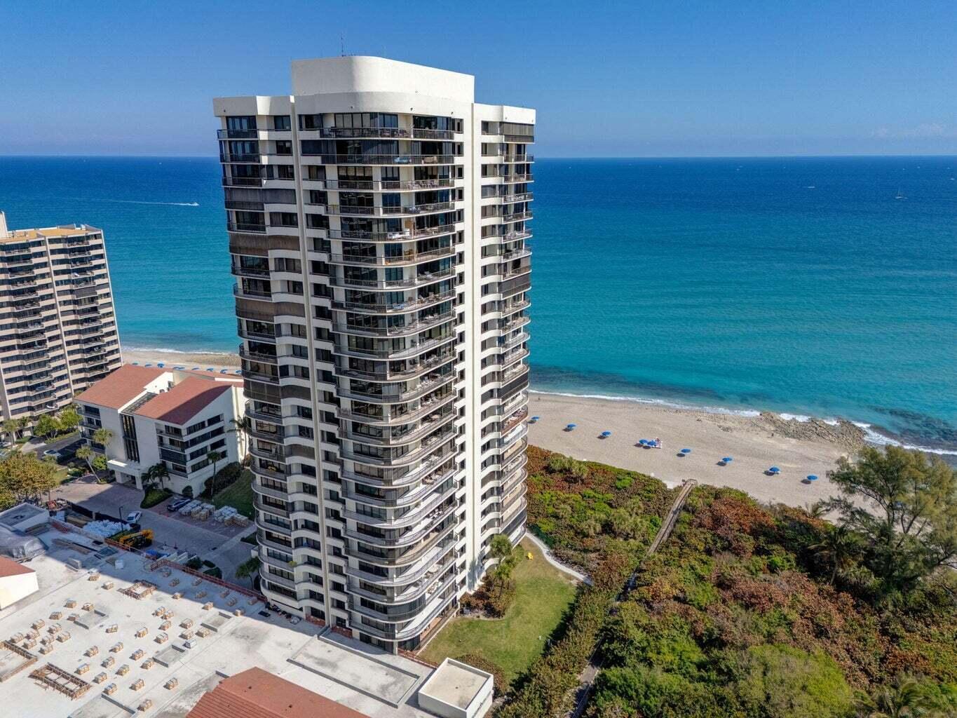 An aerial view of a tall residential high-rise building situated next to a sandy beach — 4000 N Ocean Drive # 2004, Singer Island FL 33404, SINGER ISLAND, FL