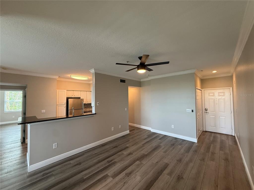 An open-concept living area features wood-look flooring, a kitchen with a breakfast bar, and a ceiling fan — 1910 E PALM AVENUE UNIT 11321, TAMPA, FL