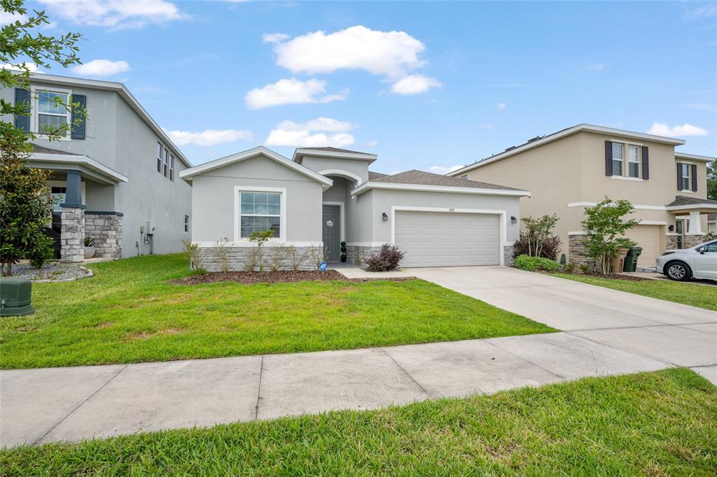 A single-story gray house with a two-car garage and stone accents on the front facade — 4372 SW 56TH PLACE, OCALA, FL