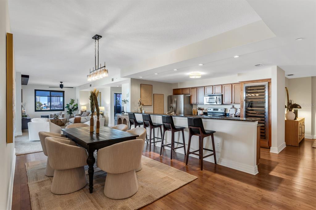An open-concept dining area and kitchen feature wood flooring, a breakfast bar, and modern lighting — 1108 N FRANKLIN STREET UNIT 605, TAMPA, FL