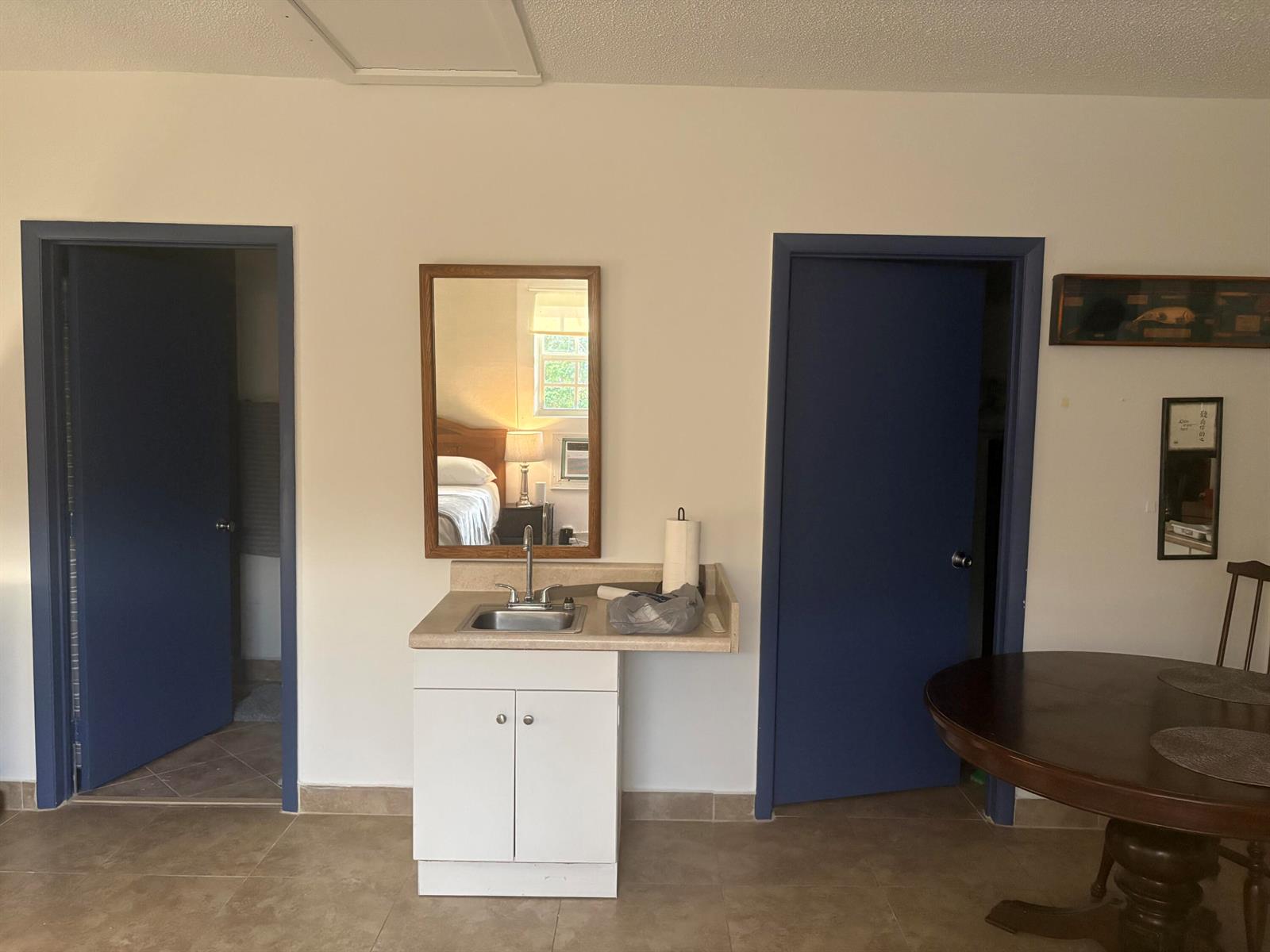 A room features a central sink vanity with a mirror between two blue doors — 10132 Windtree Lane, Boca Raton FL 33428, BOCA RATON, FL