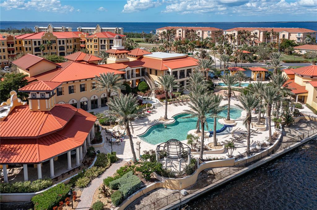 An aerial view shows a resort-style building with red roofs, a pool, and palm trees — 87 VIVANTE BOULEVARD UNIT 8742, PUNTA GORDA, FL