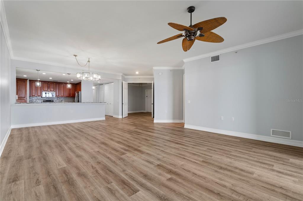 An open-concept living area features light wood-look flooring, a ceiling fan, and a kitchen pass-through — 87 VIVANTE BOULEVARD UNIT 8742, PUNTA GORDA, FL