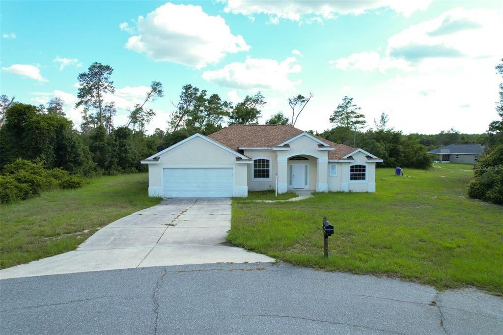 A single-story house with a white garage and front entrance sits on a grassy lot — 3858 SW 161ST STREET, OCALA, FL
