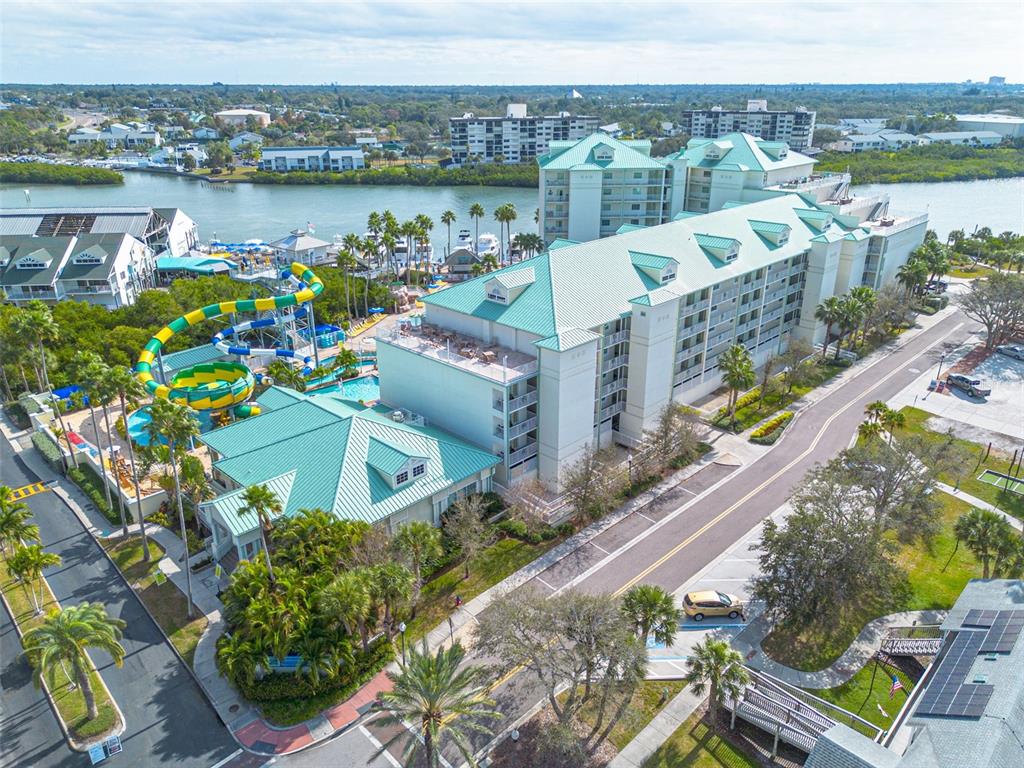An aerial view shows a large resort hotel with a water slide and pool area — 399 2ND STREET UNIT 219, INDIAN ROCKS BEACH, FL