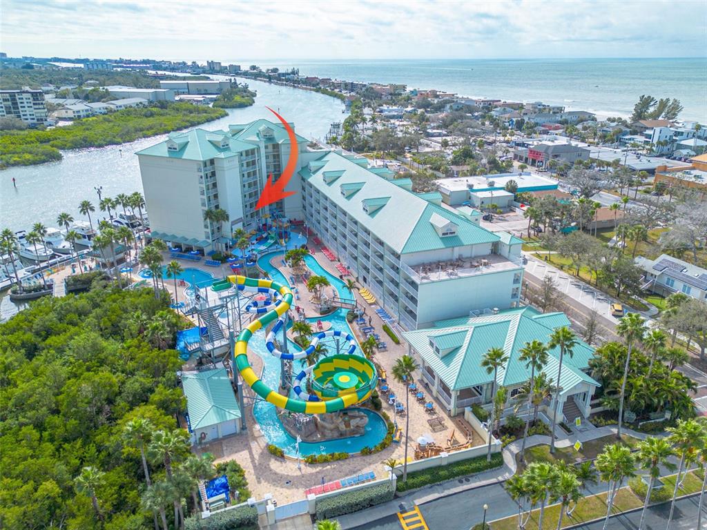 An aerial view shows a resort hotel with a water slide and swimming pool area — 399 2ND STREET UNIT 219, INDIAN ROCKS BEACH, FL