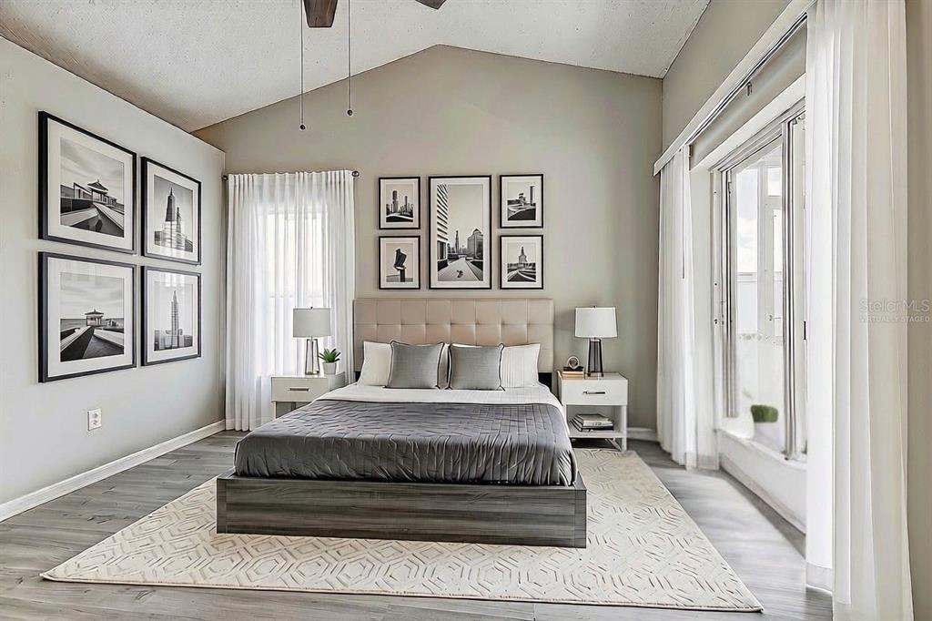 A bedroom features a platform bed, gray flooring, and a gallery wall of framed prints — 28725 SEASHELL COURT, WESLEY CHAPEL, FL