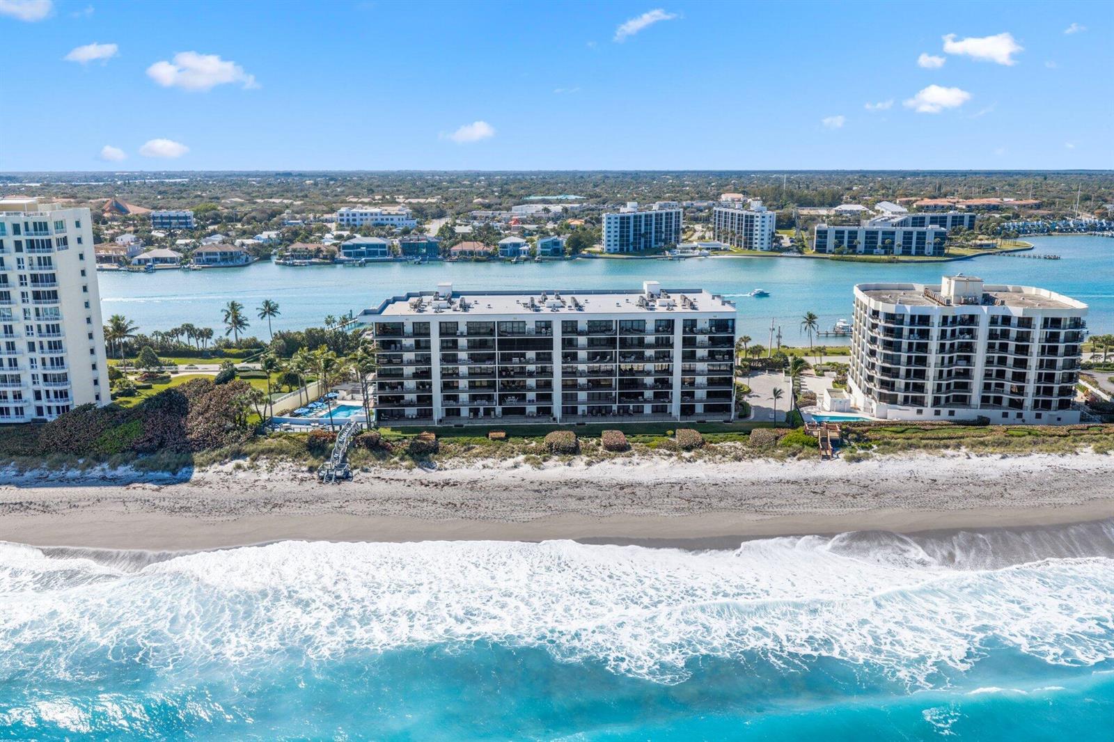 An aerial view of three beachfront apartment buildings along a sandy coastline and waterway — 19750 S Beach Road # 6050, Jupiter FL 33469, JUPITER, FL