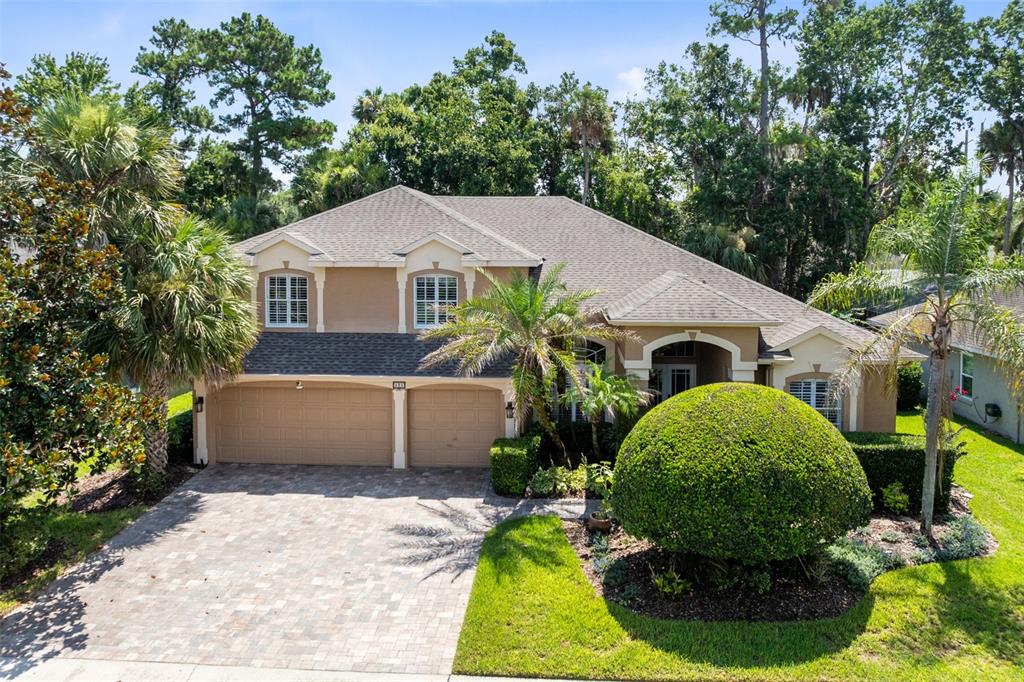 A kitchen with white cabinets, stainless steel appliances, and a lofted balcony overlooking the space — 525 SADDLEWOOD LANE, WINTER SPRINGS, FL
