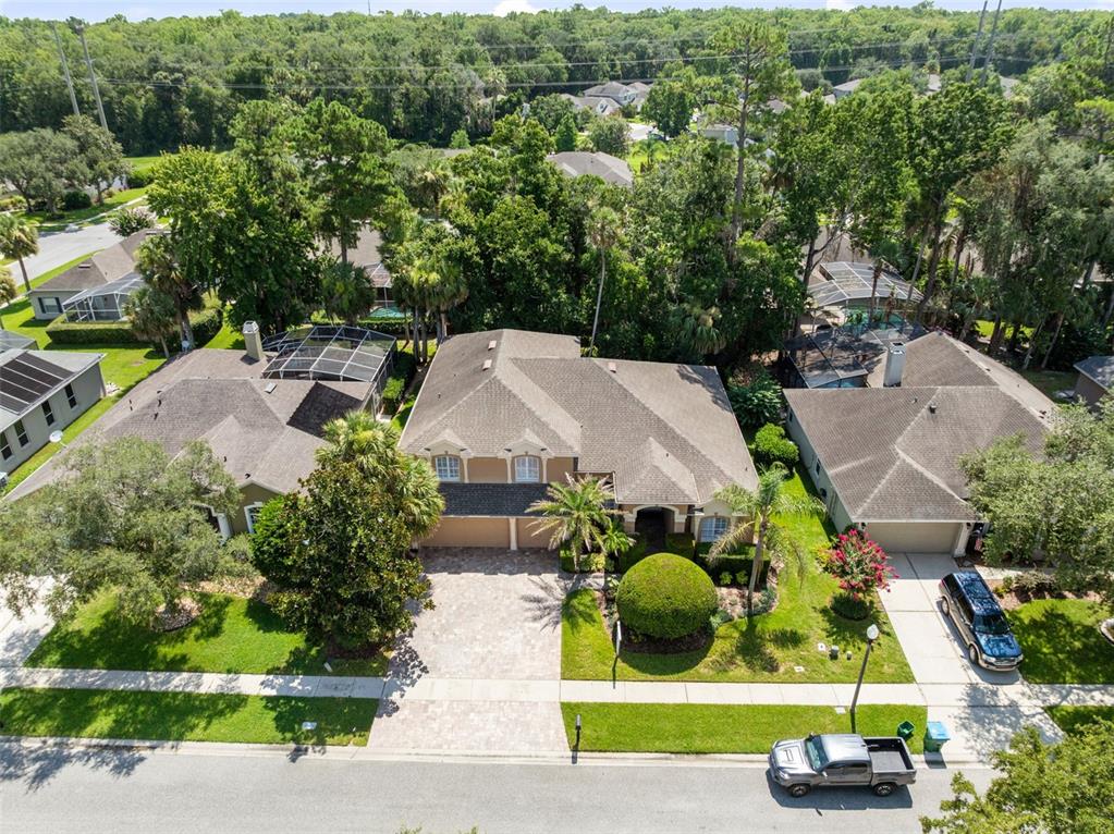 A spacious living room with tile floors, a large wooden entertainment center, and a balcony — 525 SADDLEWOOD LANE, WINTER SPRINGS, FL