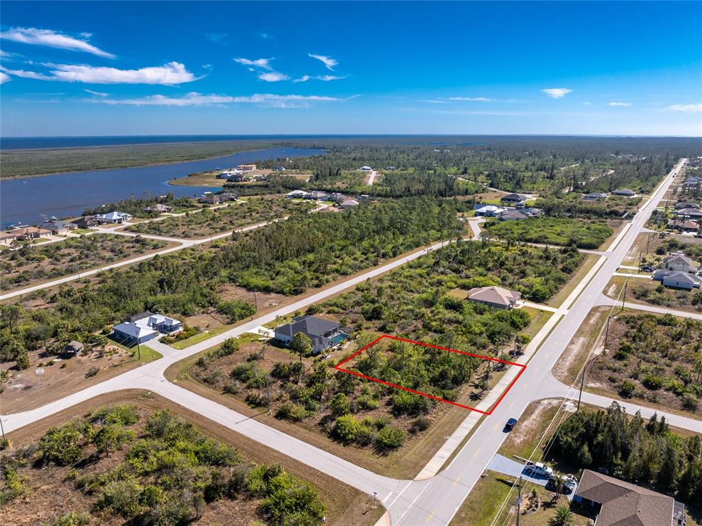 An aerial view shows a vacant, rectangular lot outlined in red within a residential neighborhood — 10096 ST PAUL DRIVE, PORT CHARLOTTE, FL
