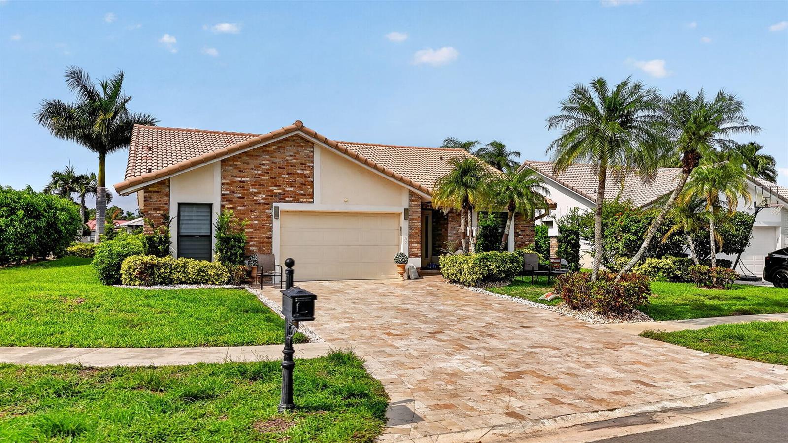 A single-story house with a brick facade, a tiled roof, and a paved driveway — 10065 Camelback Lane, Boca Raton FL 33498, BOCA RATON, FL
