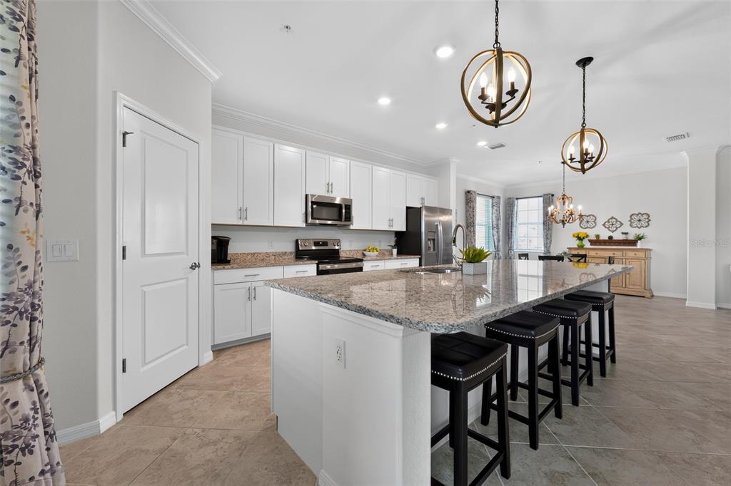 A spacious living room features tile flooring, neutral walls, two sofas, and a ceiling fan — 14648 SYCAMORE COURT UNIT 3022, PUNTA GORDA, FL