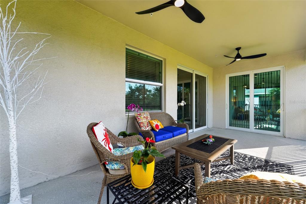 A screened-in porch features a black metal railing, a patterned rug, and outdoor furniture — 14648 SYCAMORE COURT UNIT 3022, PUNTA GORDA, FL