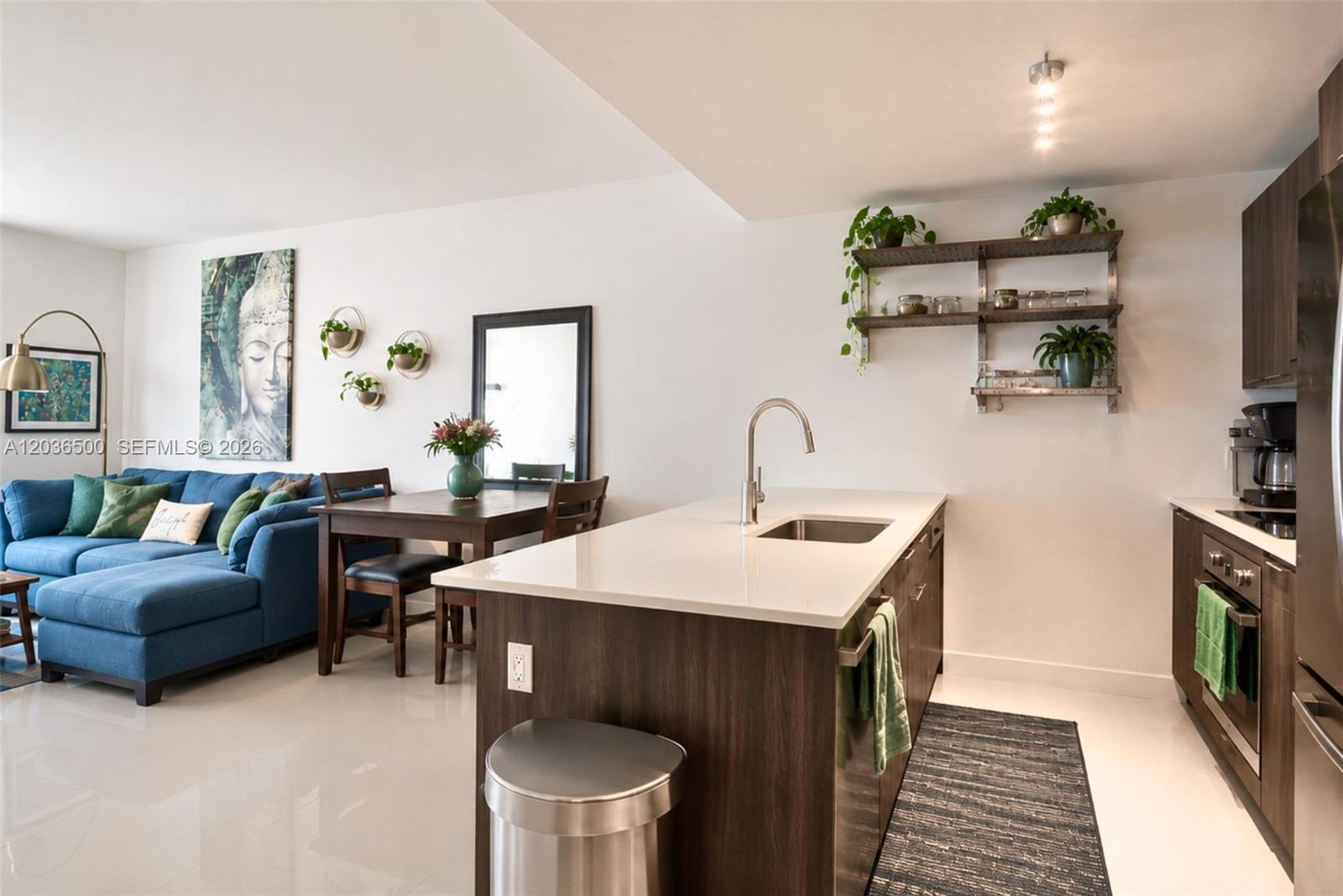 A modern kitchen with dark wood cabinets and a white island sits beside a dining area — 488 NE 18th St # 3007, Miami FL 33132, MIAMI, FL