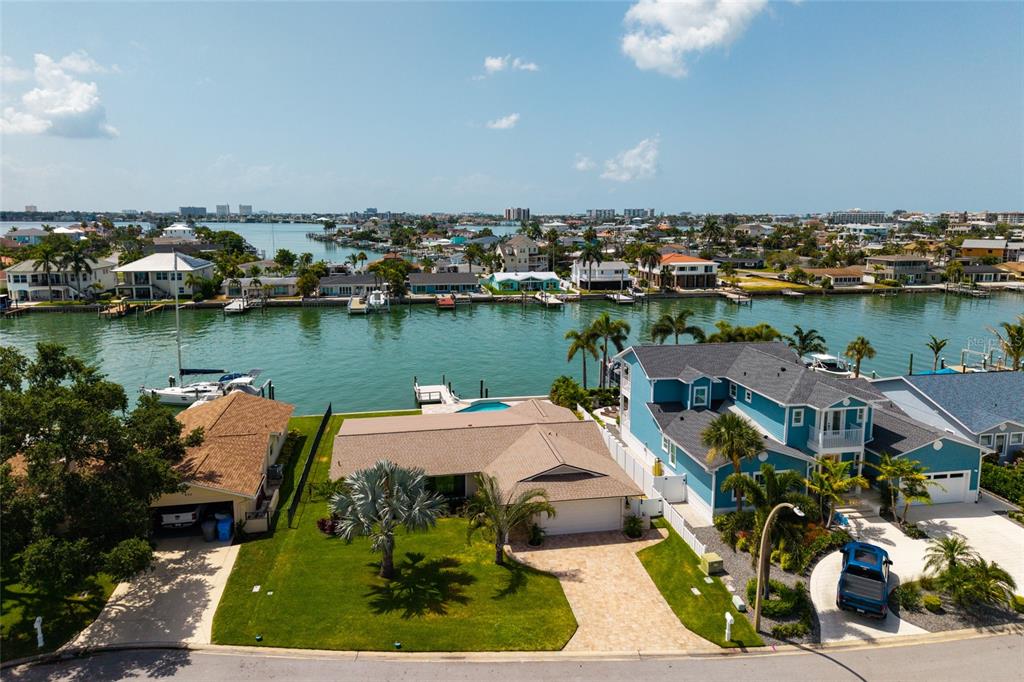 An aerial view shows two waterfront homes with docks and boats along a canal — 825 116TH AVENUE, TREASURE ISLAND, FL