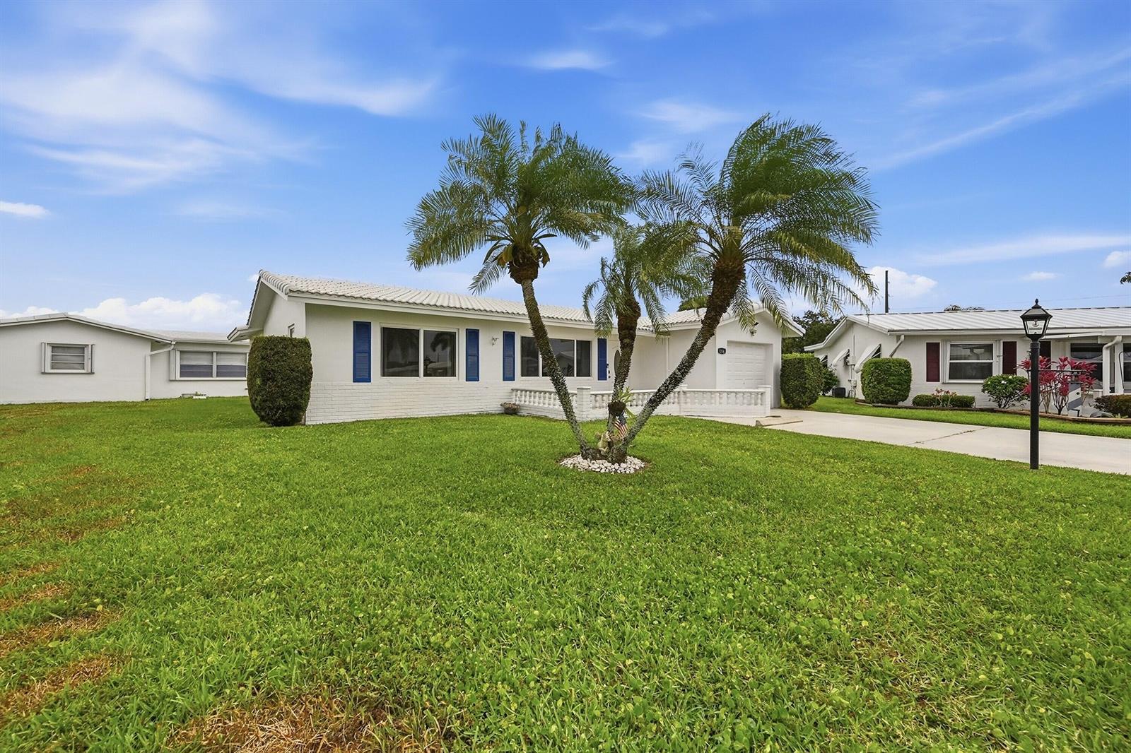 A white single-story house with blue shutters and a palm tree in the front yard — 1316 SW 23rd Street, Boynton Beach FL 33426, BOYNTON BEACH, FL
