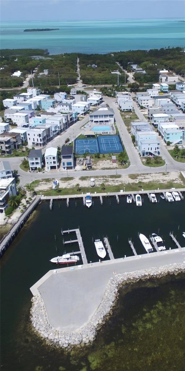 An aerial view shows a coastal residential community with a marina, pool, and tennis courts — 94825 Overseas Hwy 116, Key Largo FL 33037, KEY LARGO, FL