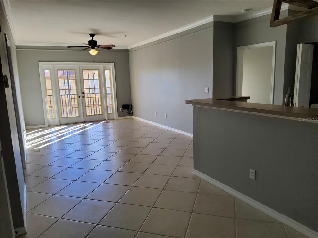 An open living area features light gray walls, tile flooring, and a glass-paneled door — 4333 BAYSIDE VILLAGE DRIVE UNIT 224, TAMPA, FL