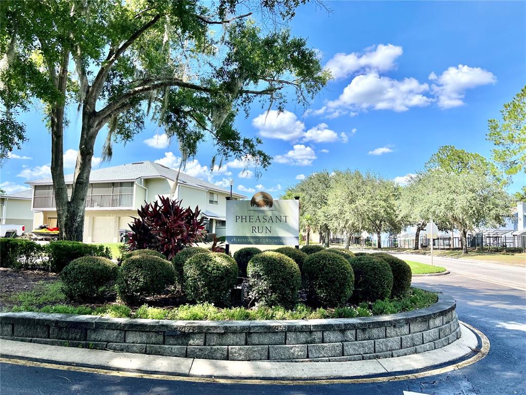 A sign for Pheasant Run at Rosemont Condominiums stands behind a landscaped garden bed — 4562 PHEASANT RUN DRIVE UNIT 9B, ORLANDO, FL