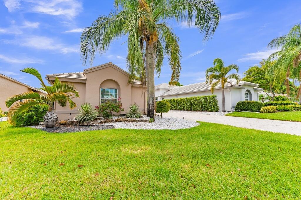 A single-story house with a beige exterior, a paved driveway, and palm trees in front — 6429 Three Lakes, Boynton Beach FL 33437, BOYNTON BEACH, FL