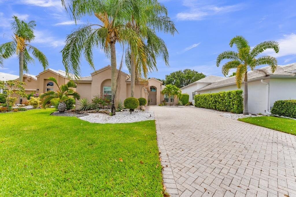 A paved driveway leads to the entrance of a tan house with palm trees — 6429 Three Lakes, Boynton Beach FL 33437, BOYNTON BEACH, FL