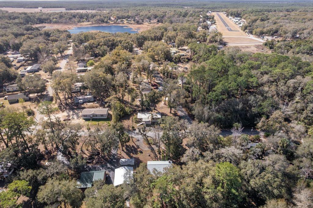 An aerial view shows a rural residential area with scattered houses, trees, and an airstrip — 16302 SE 57TH STREET, OCKLAWAHA, FL