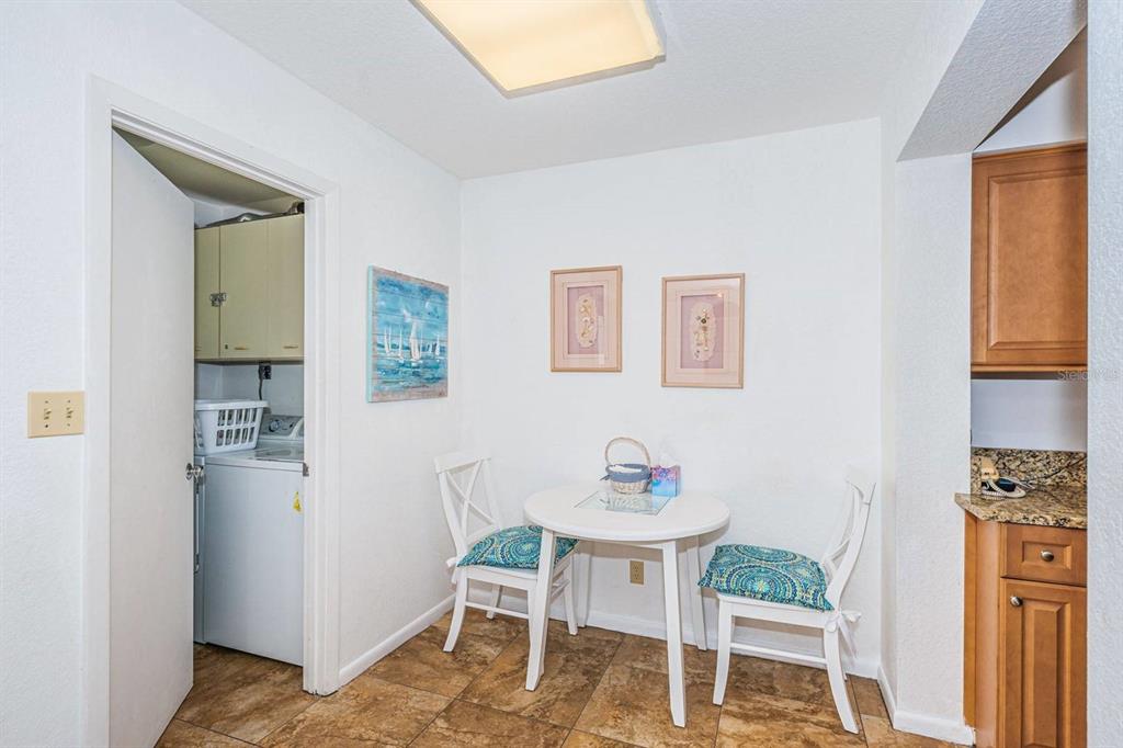 A small dining area features a white table, two chairs, tile flooring, and a laundry closet — 5801 BAHIA DEL MAR CIRCLE UNIT 512, ST PETERSBURG, FL