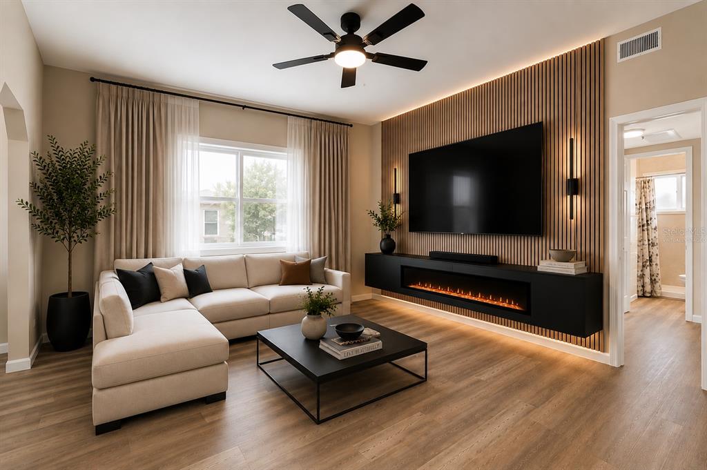 A living room features a sectional sofa, a wall-mounted fireplace, and wood slat wall paneling — 8616 SHIRLEY DRIVE, TEMPLE TERRACE, FL