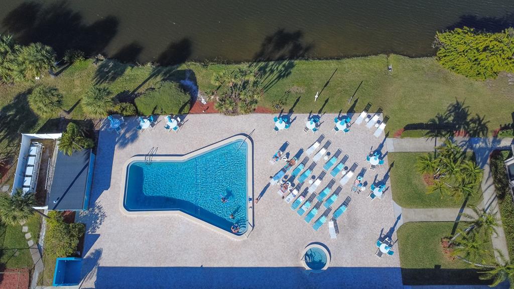 An aerial view of a swimming pool and hot tub surrounded by lounge chairs — 9860 62ND TERRACE N UNIT 1014, ST PETERSBURG, FL