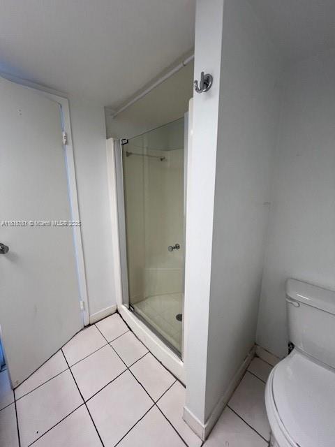 A bathroom features a glass-enclosed shower, white tile flooring, and a white toilet — 13499 Biscayne Blvd # 602, North Miami FL 33181, NORTH MIAMI, FL