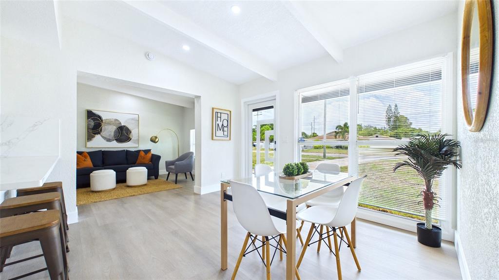 A bright dining area with a glass table connects to a living room with seating — 4103 W PEARL AVENUE, TAMPA, FL